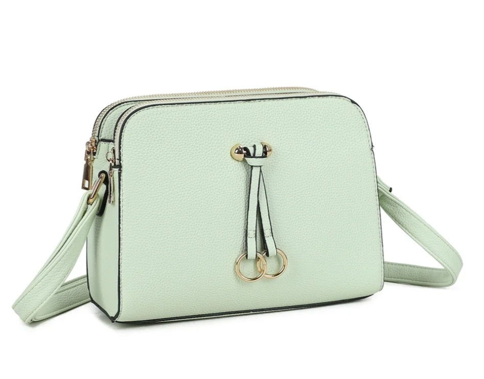 Pale pink crossbody bag with double zip and ring charms