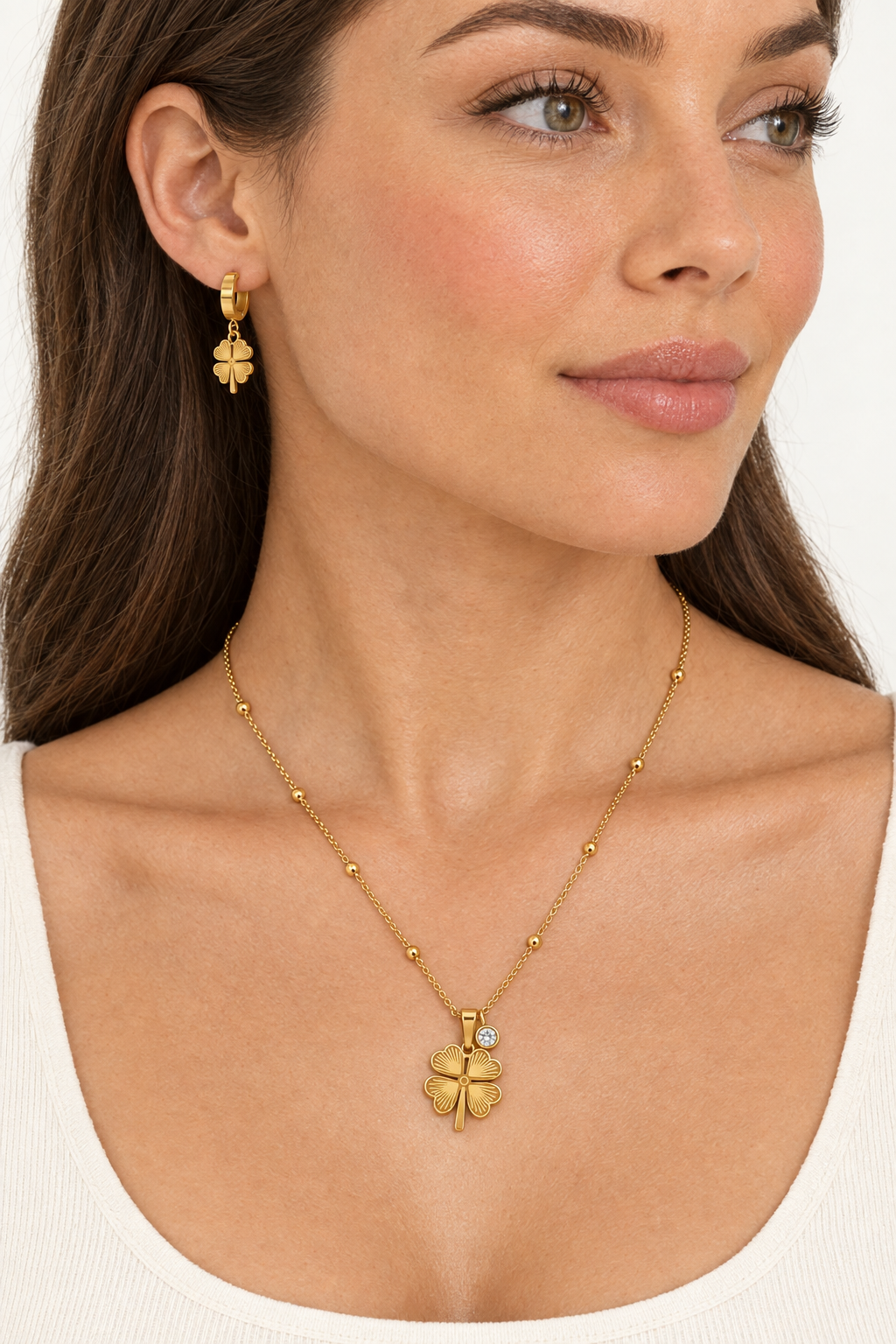 Side view of model wearing clover earrings and necklace